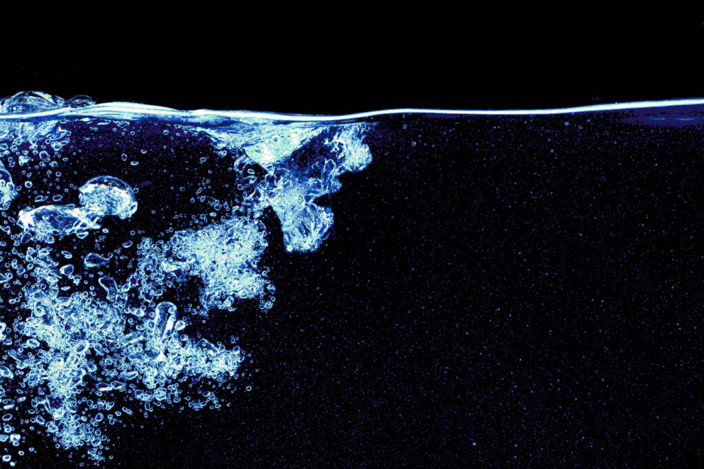 Water splash in aquarium isolated on black background close up