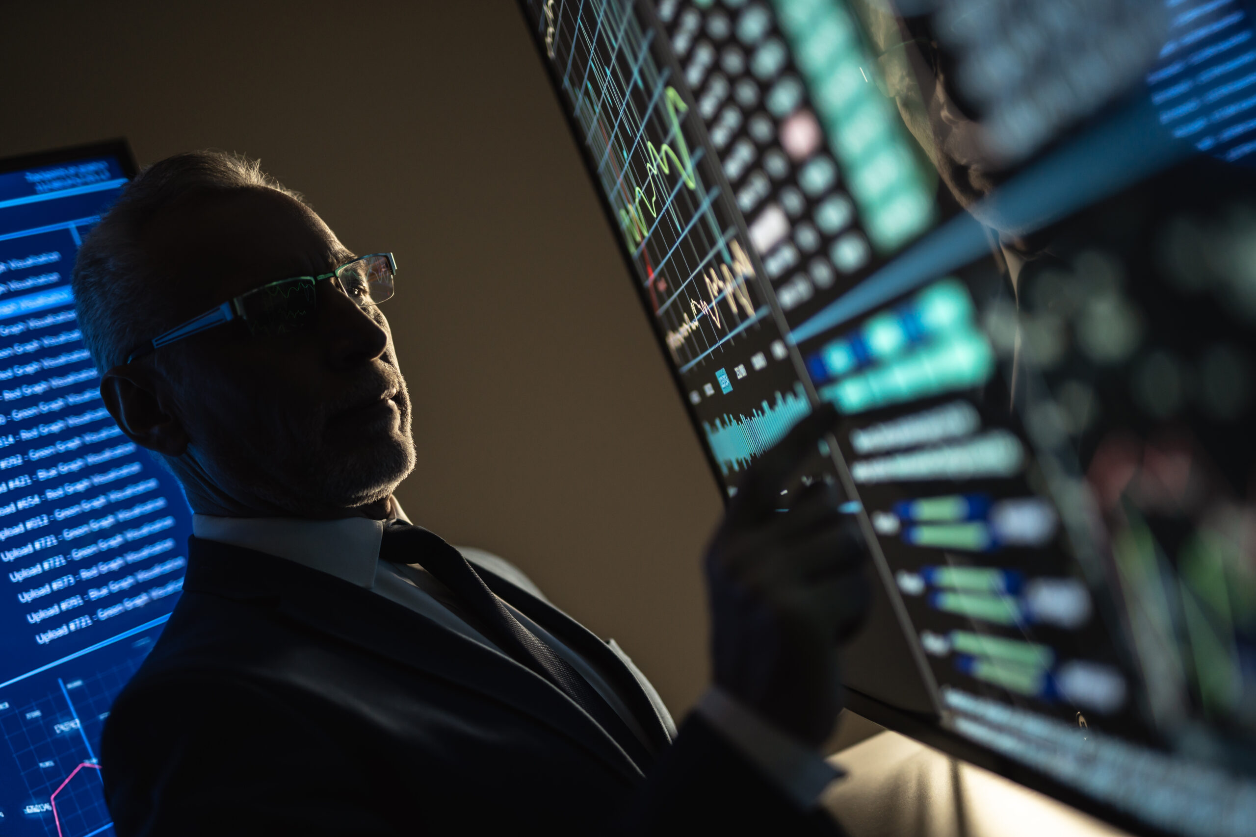 old businessman working on a big screen investment