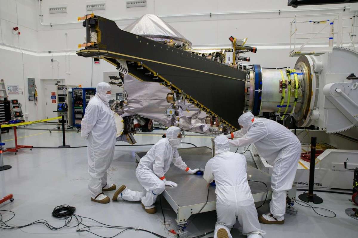 Workers inside the Astrotech Space Operations Facility in Florida work to open and extend one of the solar arrays on NASA’s Lucy spacecraft on Aug. 19, 2021.