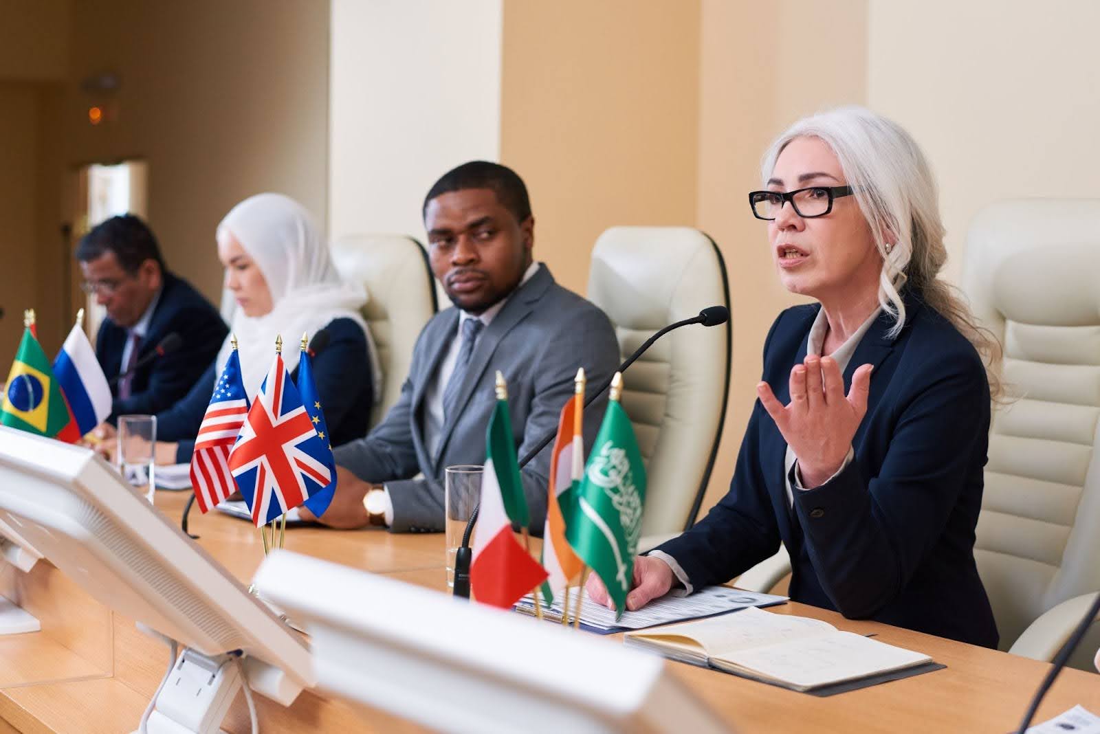 A conference people sitting at a table with national flags