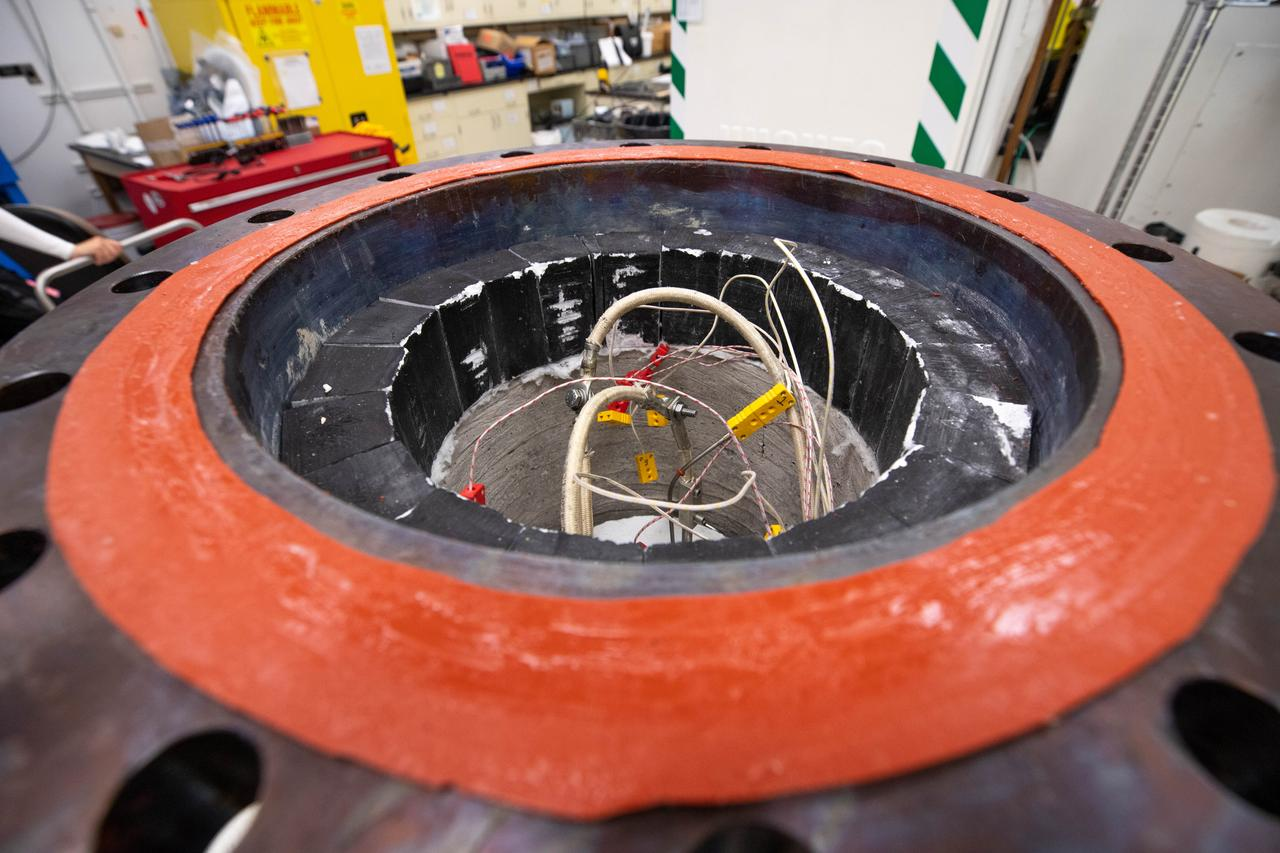 Close-up of industrial component with exposed wires in workshop.